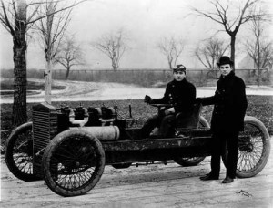 Ford, Henry Ford, standing, and Barney Oldfield in 1902 with the 999 racing automobile