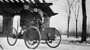 Ford Mr. and Mrs. Ford in his first car, which he sold but afterwards bought back; it became his most prized possession.  Notice the old fashioned bicycle wheels and the bell on the dash, public domain image